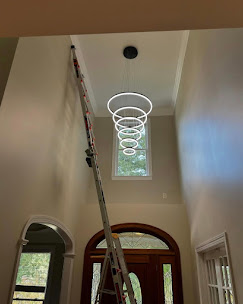 Modern chandelier hanging in a tall stairwell